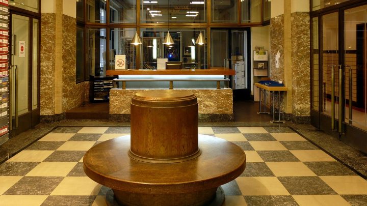 Medewerker aan bureau in gemeentekantoor kijkt naar salarisschalen op computerscherm